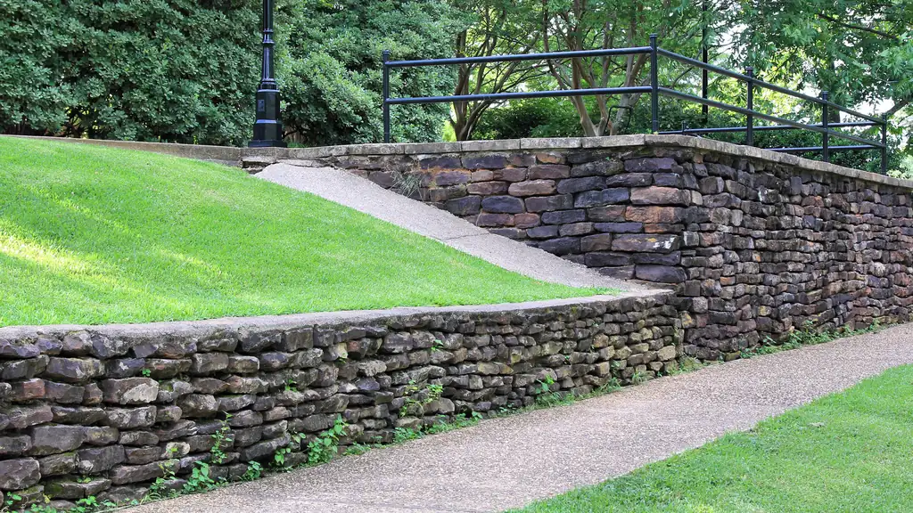 Curving natural stone retaining walls terracing a sloped lawn